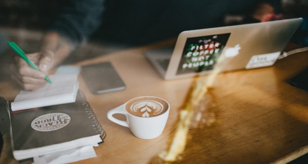 Person sitting in a cafe with a laptop