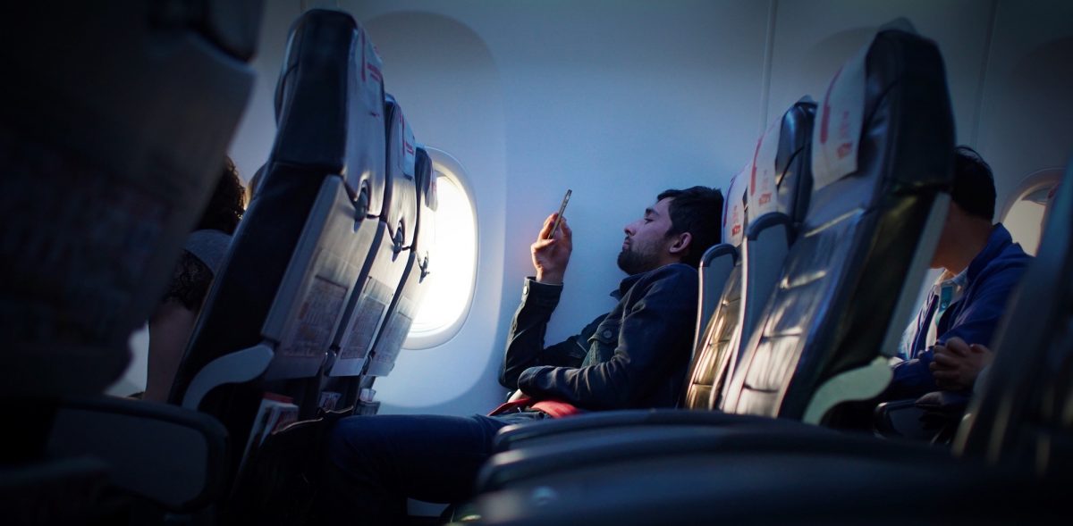 Checking the phone on the plane photo by Javier Cañada on Unsplash